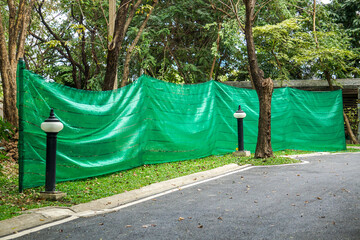 Green slanding net is used to cover the electric train base structure, used for temporary wall...