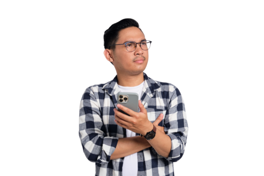 Pensive young Asian man in casual shirt holding smartphone, looking aside at copy space, thinking about offer isolated on transparent background
