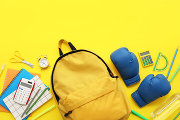 Composition with backpack, school supplies and sports equipment on yellow background