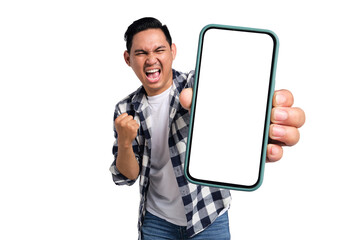 Yes. Excited young Asian man in casual shirt holding smartphone with blank screen and clenching...