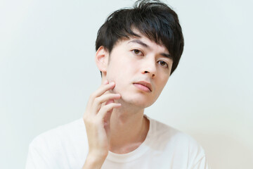 肌の状態を確かめる若い男性