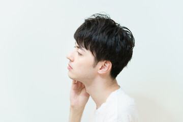 肌の状態を確かめる若い男性