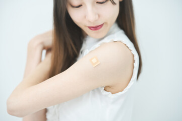 ワクチン接種のパッチが貼られた女性の腕