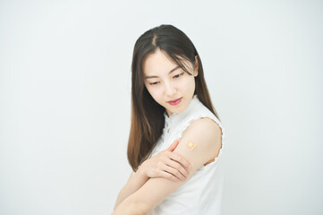 ワクチン接種のパッチが貼られた女性の腕