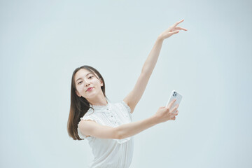 スマートフォンを持ちながら舞う若い女性