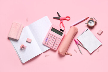Composition with different school stationery, alarm clock and calculator on pink background