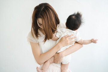 赤ちゃんを抱えて、疲れた表情をするお母さん