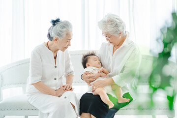 Obraz premium 赤ちゃんを抱っこするシニア女性たち