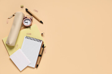 Composition with different school stationery and alarm clock on beige background