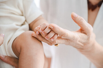 赤ちゃんを抱っこしてふれあうシニア女性