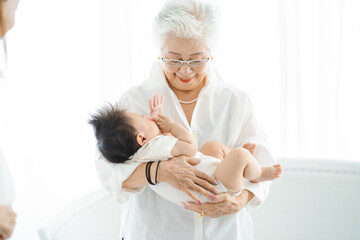 赤ちゃんを抱っこするシニア女性