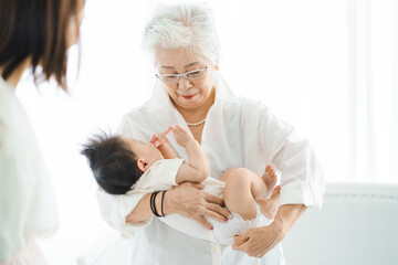 赤ちゃんを抱っこするシニア女性