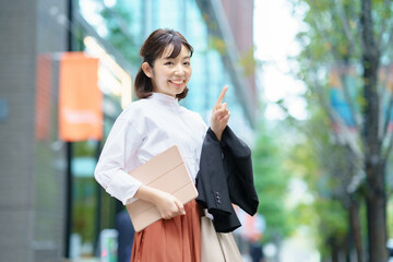 人差し指を立てるポーズをする女性