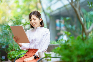 屋外でタブレットPCを使う女性