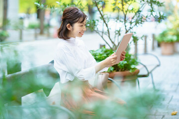 屋外でタブレットPCを使う女性