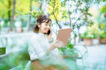 屋外でタブレットPCを使う女性