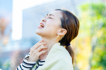 喉の痛みを気にする女性