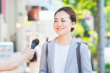 街頭インタビューを受けるビジネスウーマン