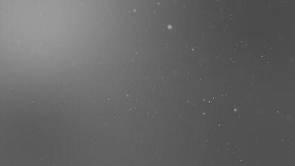 灰色の空間に浮遊するたくさんの光る粒子