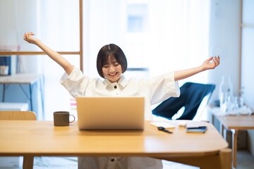 在宅での仕事中に深呼吸する女性