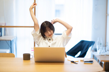 在宅での仕事中に深呼吸する女性