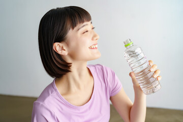スポーツウェア姿で水分補給をする女性