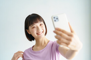 スポーツウェア姿でスマートフォンの画面を見る女性
