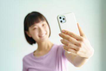 スポーツウェア姿でスマートフォンの画面を見る女性