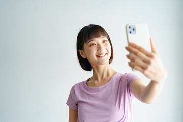 スポーツウェア姿でスマートフォンの画面を見る女性