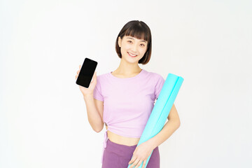 スポーツウェア姿でスマートフォンを持つ女性