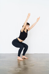 Obraz premium ヨガ（椅子のポーズ）をする女性