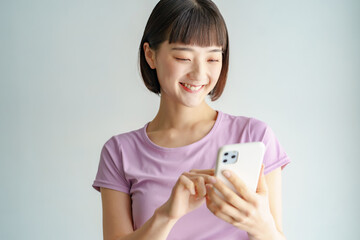 スポーツウェア姿でスマートフォンを持つ女性