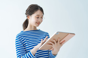 タブレットPCの画面を見る若い女性