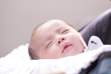 In June 2025, a one-month-old Japanese baby is held in a parent's arms during their first shrine...