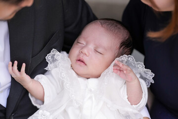 In June 2025, a Japanese couple in their early twenties sits on a stone wall with their...