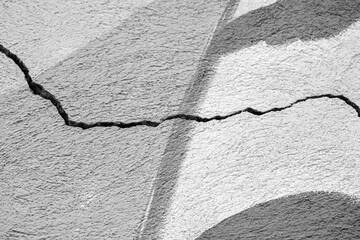 Big winding crack on old plastering wall. Copy space.  Black and white photo. Selective focus.