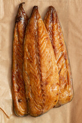 Honey glazed smoked mackerel fillets on a brown paper background backdrop.