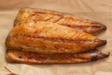 Honey glazed smoked mackerel fillets on a brown paper background backdrop.