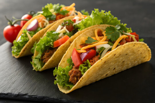 Tacos on dark black background for National Taco Day - Powered by Adobe