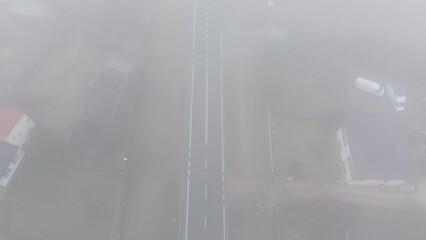 Mountain road covered in fog seen from above