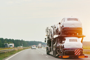 Covered cars on a truck heading down highway