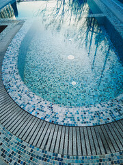 Modern swimming pool with transparent water. Close-up, vertical photo.