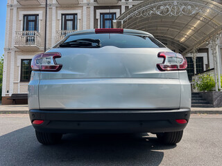 A stylish silver SUV is elegantly parked in front of a classic building that showcases intricate...