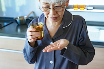 錠剤を飲むシニア女性