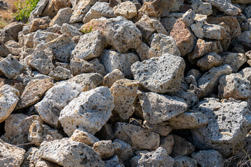 Pile of porous volcanic tuff stones in sunlight. Traditional building material in Tokaj wine region, Slovakia. Natural texture and rough surface.