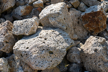 Close-up of porous volcanic tuff stones in sunlight. Traditional material from Tokaj region, Slovakia, used in rural architecture and wine cellars.