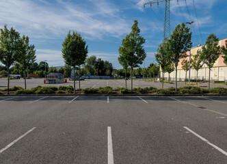 Empty Supermarket Parking Lot in Bright Sunshine, Showing Urban Stillness, Everyday Infrastructure, and the Stark Clarity of a Quiet Commercial Space