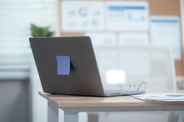 Neatly arranged office workspace features desk with computer, laptop, documents, charts, pinboard, representing professional, business environment ready for efficient work and information management