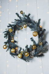 An Elegant Gold and Green Christmas Wreath, beautifully adorned with various Festive Ornaments,...