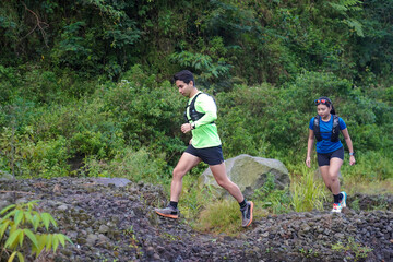 Asian Indonesian couple trail running outdoors, active sustainable lifestyle exercise
